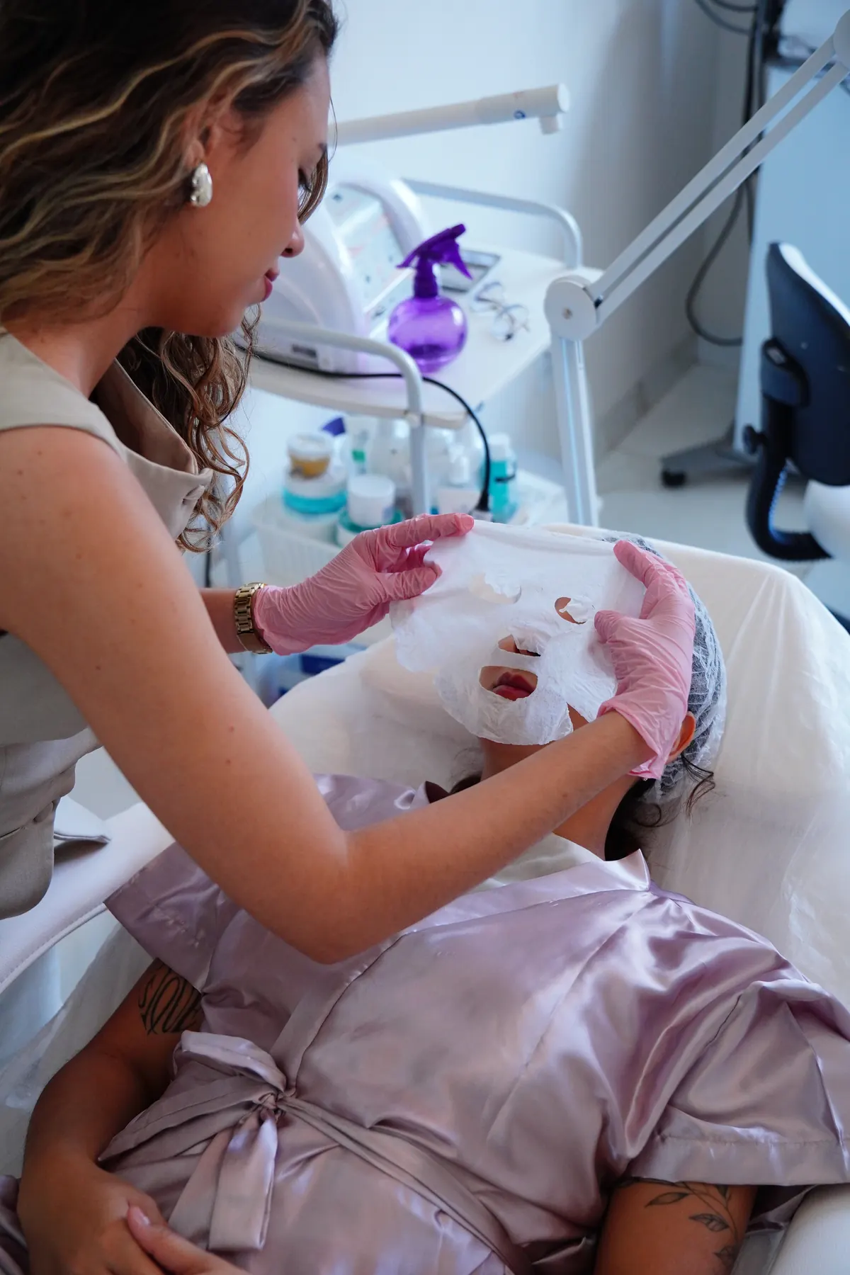 Profissional aplicando máscara facial durante atendimento estético na D’Life